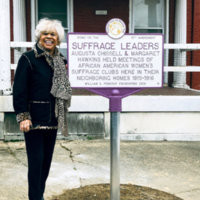 Chissell’s great niece Carolyn Chissell standing beside the marker dedicated to Chissell and Margaret Hawkins at 1534 Druid Hill Ave